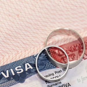 Two wedding rings on top of a visa, possibly symbolizing a marriage of convenience.