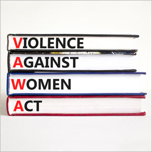 A stack of books with titles "Violence Against Women," "Women Act," and "Women" symbolizing empowerment through VAWA - The Emory Law Firm