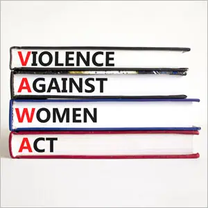 A stack of books with titles "Violence Against Women," "Women Act," and "Women" symbolizing empowerment through VAWA - The Emory Law FIRM PC