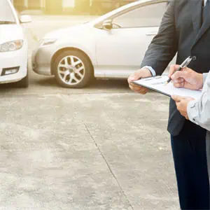 People signing documents after a car accident